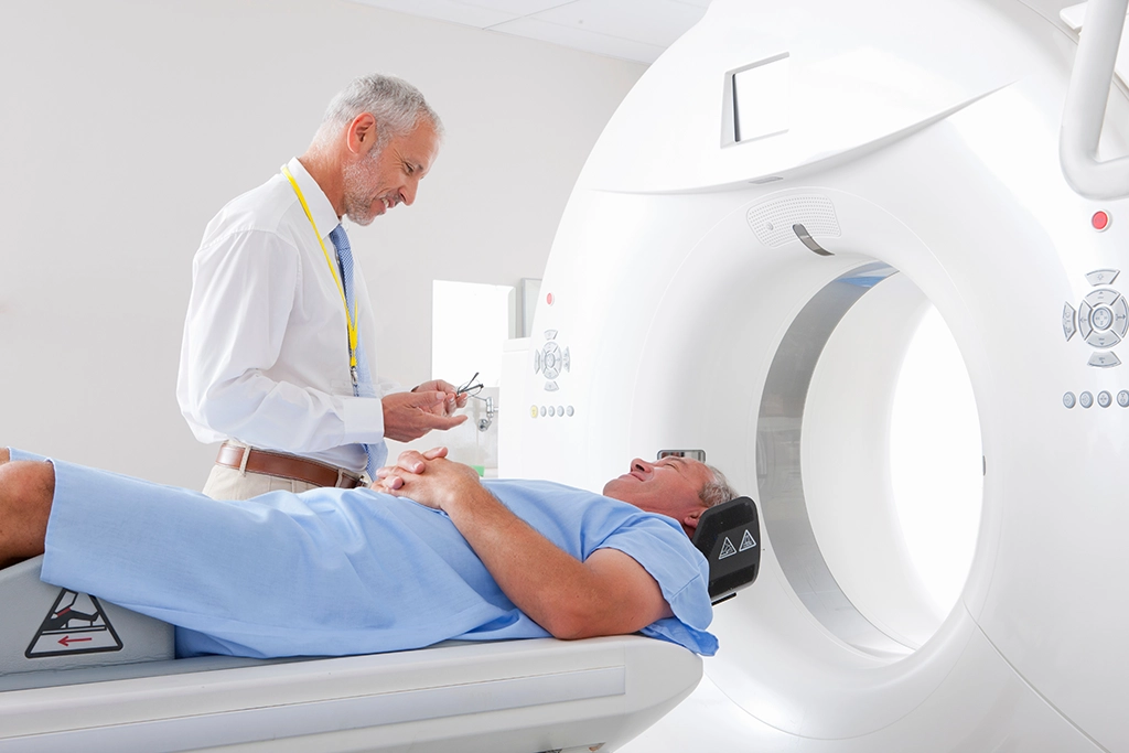 CT Technologist Speaking With Male Patient on CT Scan Table