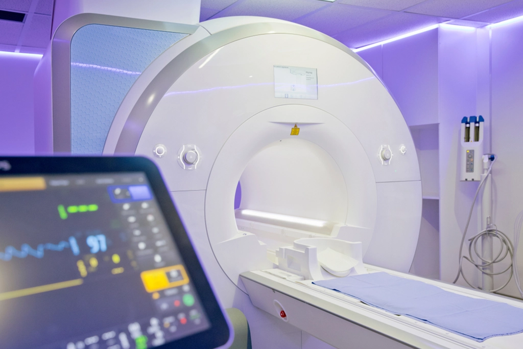 An Empty MRI Scan Machine With Purple Lighting & Vital Signs