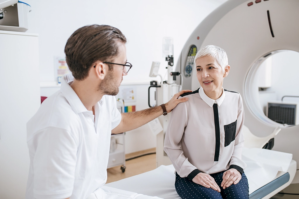 CT Scan Technologists Consults Older Female Patient Before CT Scan