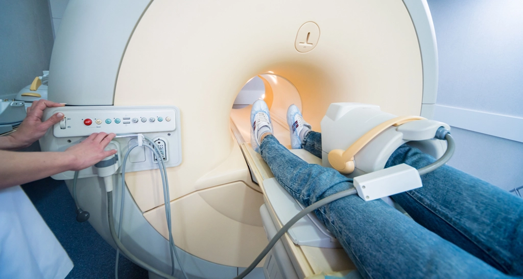 MRI Technologist Operating A Knee MRI For A Female Patient
