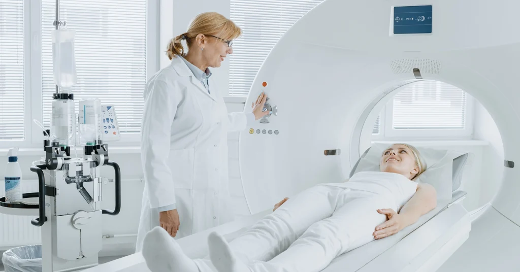 Female Technologists Smiles At Female Patient During PET/CT Scan