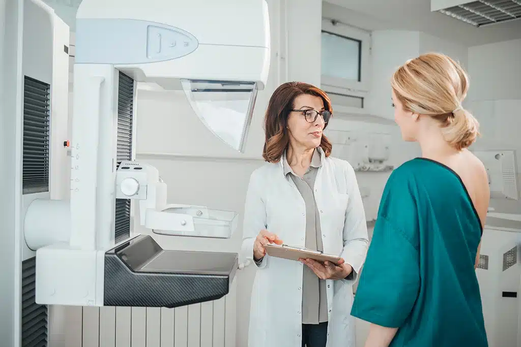 Breast Imaging Technologist Explaining A 3D Mammogram To Her Patient