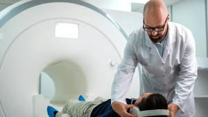 MRI Technologist Placing Headphones On Young Male Patient Before MRI