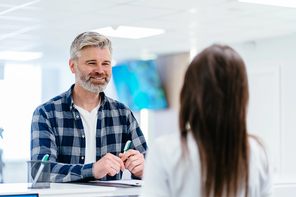 Man With Pelvic Pain Checking In For CT Scan Appointment