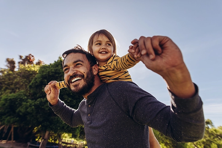 Dad Playing Outside With His Kid On Shoulders