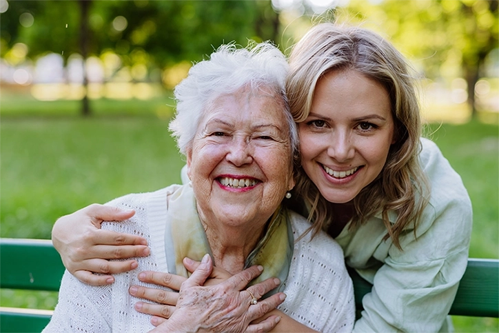 Daughter Hugging Mom On Park Bench