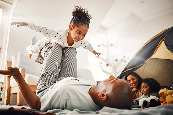 Father Playing With Daughter Lifting With Knees