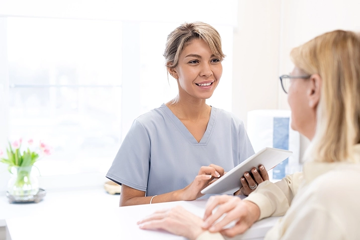 PET Imaging Technologist Speaking With Patient About Her Study