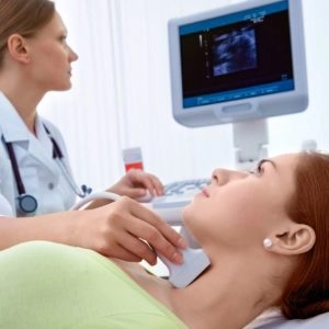 Ultrasound Technologist Performing Neck Ultrasound On Patient