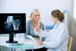 X-Ray Technologist Showing X Ray of Hip Results To Patient